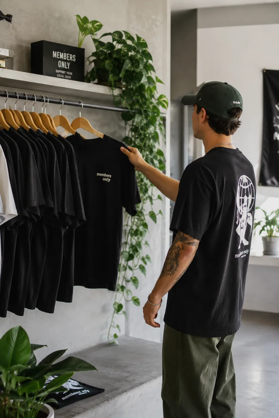 A shopper browsing a rack of Members Only tees in a studio boutique